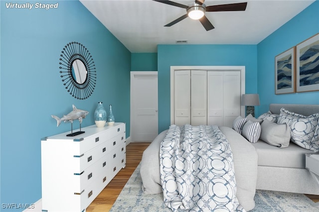 bedroom featuring a closet, light wood-type flooring, and ceiling fan