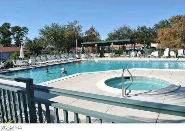 view of swimming pool with a patio area and a community hot tub