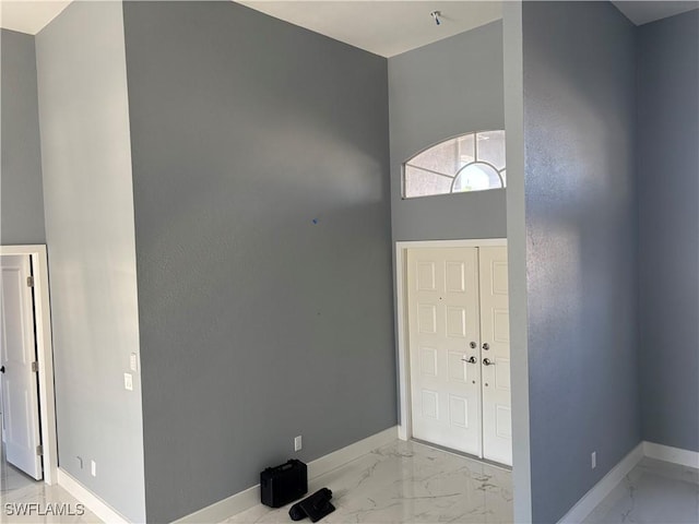 foyer entrance featuring a towering ceiling