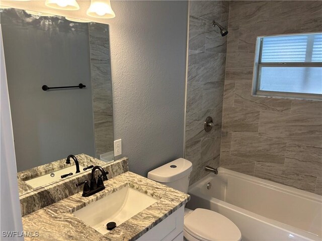 full bathroom with vanity, toilet, and tiled shower / bath