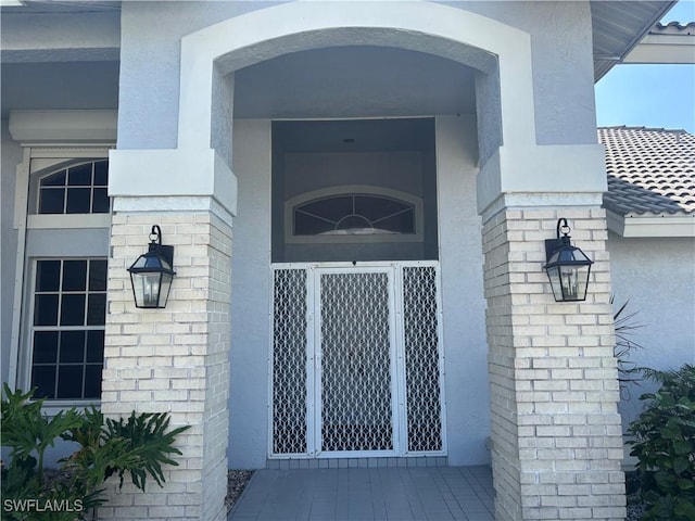 entrance to property featuring stucco siding