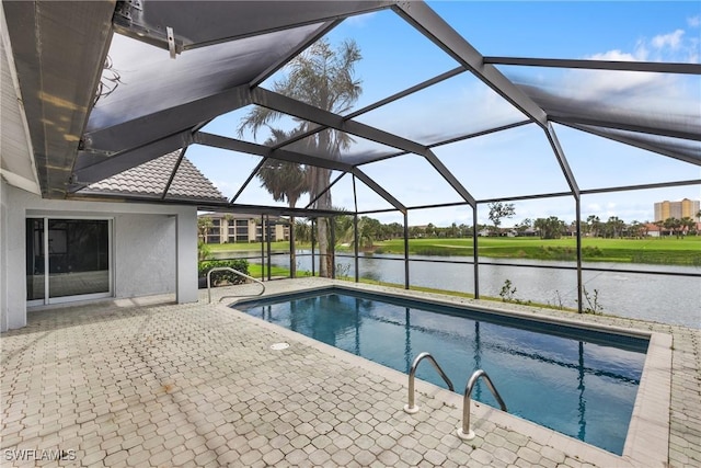 outdoor pool with a patio, a water view, and glass enclosure