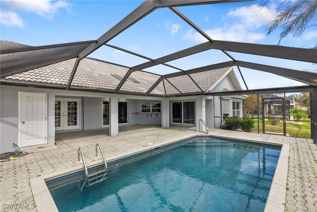 outdoor pool featuring french doors, glass enclosure, and a patio