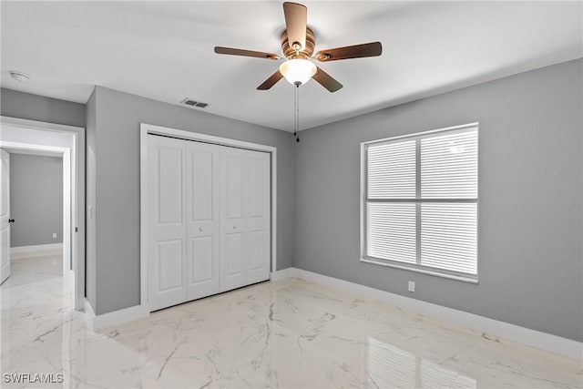 unfurnished bedroom with marble finish floor, visible vents, baseboards, and a closet