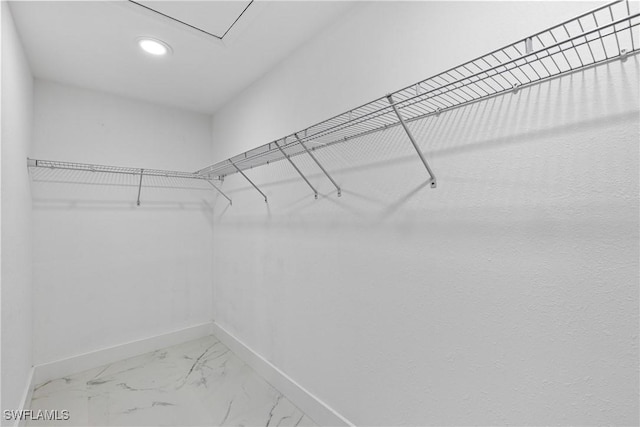 walk in closet with marble finish floor