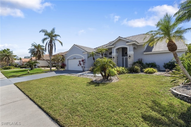 view of front of house featuring stucco siding, a garage, driveway, a tiled roof, and a front lawn