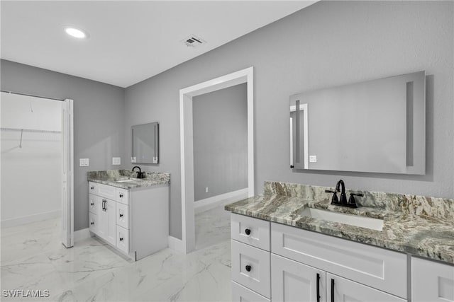 bathroom featuring marble finish floor, two vanities, a sink, and visible vents