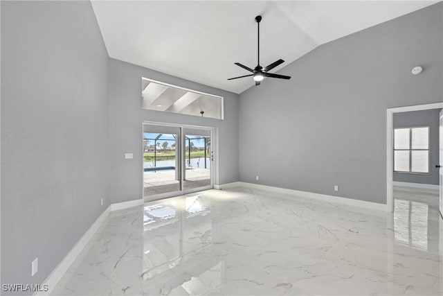 spare room featuring high vaulted ceiling, marble finish floor, ceiling fan, and baseboards