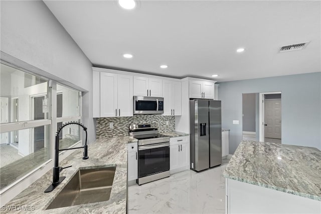 kitchen with visible vents, marble finish floor, stainless steel appliances, white cabinetry, and a sink