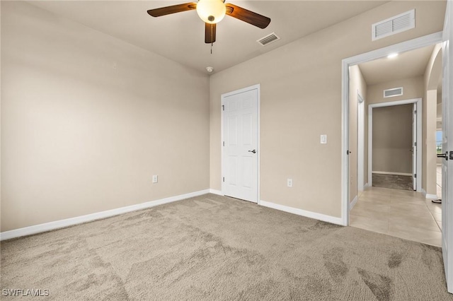 unfurnished bedroom featuring ceiling fan, light carpet, and a closet