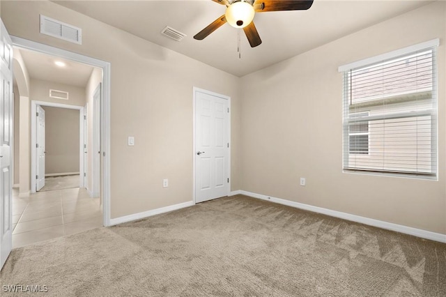 empty room with ceiling fan and light colored carpet