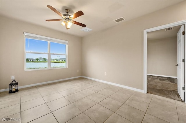 tiled empty room featuring ceiling fan