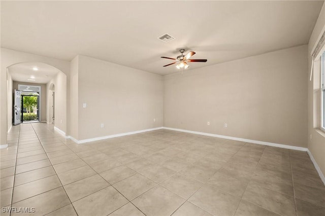 tiled empty room featuring ceiling fan