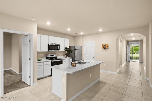 kitchen featuring white cabinets, stainless steel appliances, sink, a kitchen island with sink, and light tile patterned floors