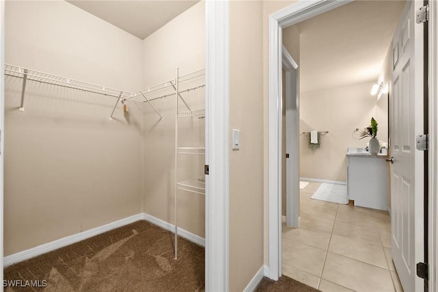 walk in closet with light tile patterned floors