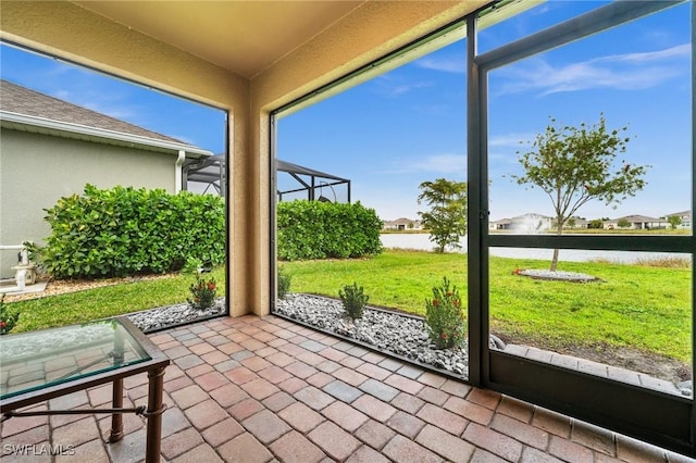 unfurnished sunroom featuring a water view