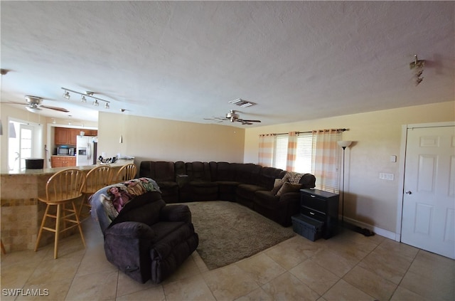 living room with rail lighting, ceiling fan, and a healthy amount of sunlight