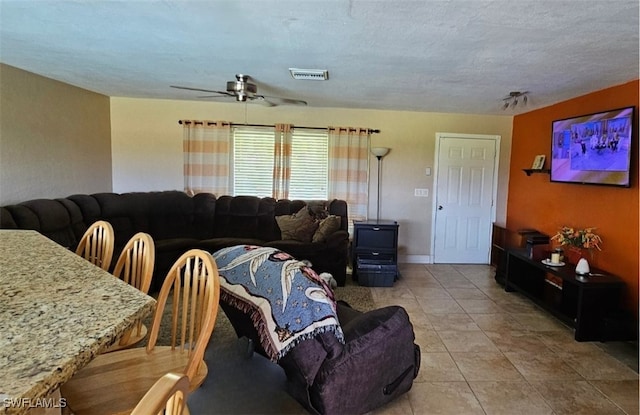 tiled living room featuring a textured ceiling and ceiling fan