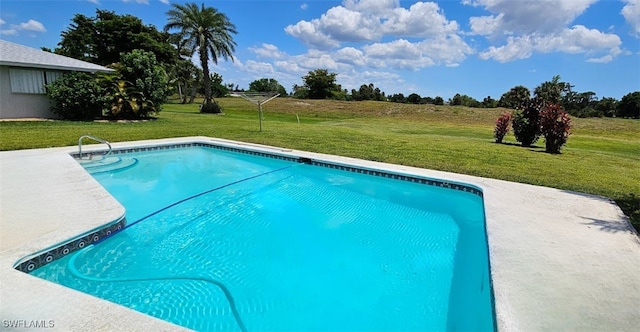 view of swimming pool featuring a yard