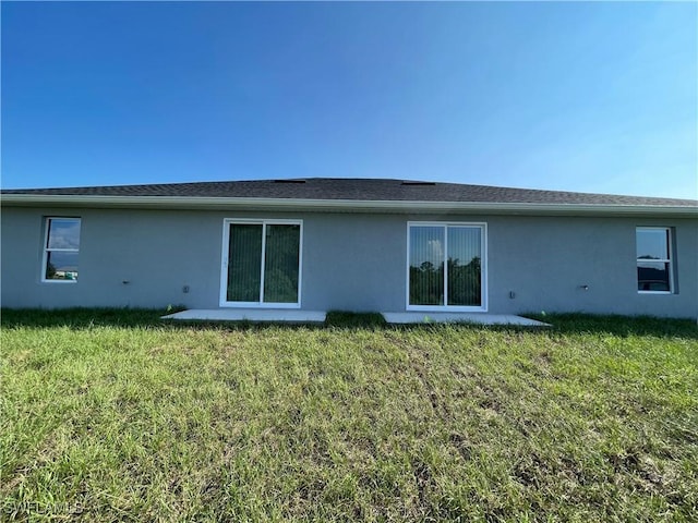 rear view of house featuring a lawn