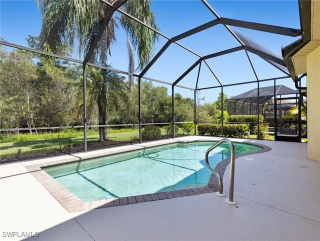 view of swimming pool featuring a patio area and glass enclosure