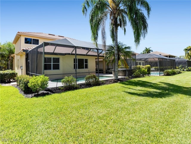 rear view of property featuring a yard and glass enclosure