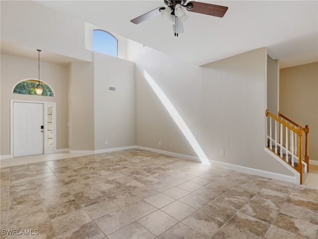 interior space with a wealth of natural light, a high ceiling, and ceiling fan