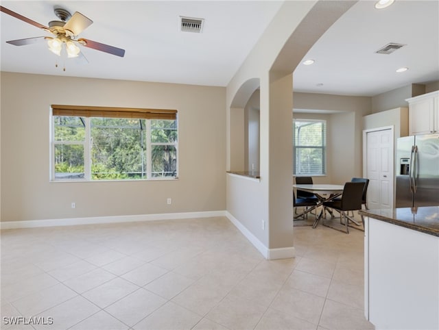 tiled spare room featuring ceiling fan