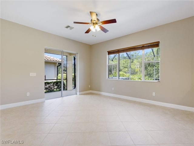 empty room with ceiling fan and light tile patterned floors