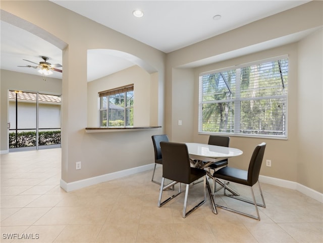 tiled dining area featuring a healthy amount of sunlight and ceiling fan