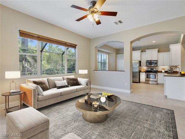 living room with ceiling fan and sink