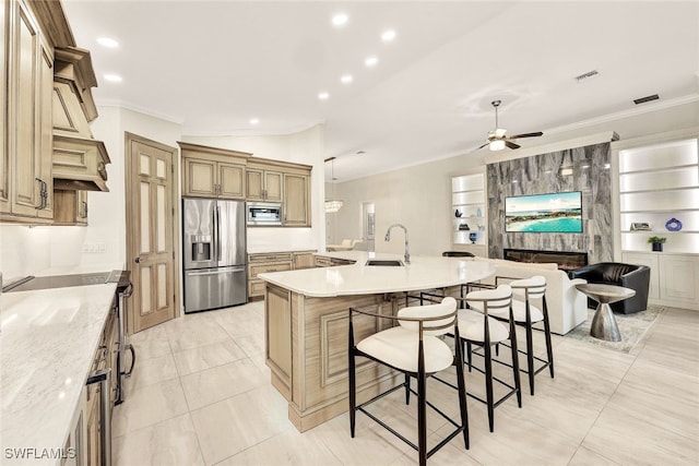 kitchen featuring a breakfast bar area, stainless steel appliances, crown molding, and a ceiling fan