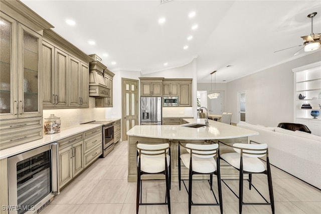 kitchen with a kitchen bar, beverage cooler, a sink, open floor plan, and stainless steel appliances