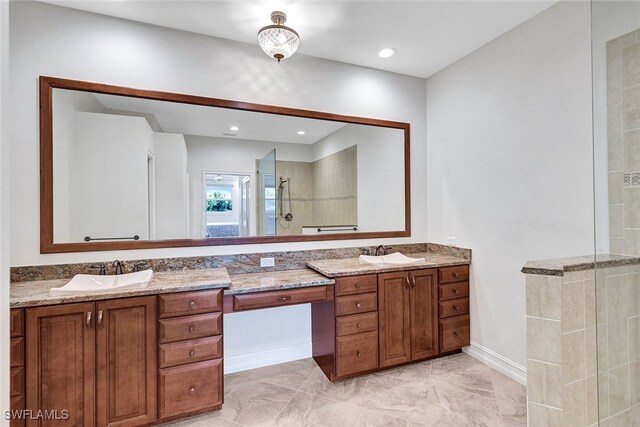 bathroom featuring a tile shower and vanity