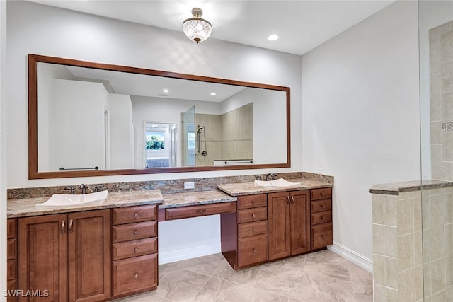 full bath featuring double vanity, recessed lighting, tiled shower, and a sink