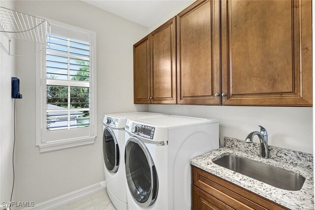 washroom with cabinets, separate washer and dryer, light tile patterned flooring, and sink