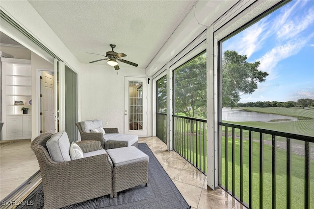 sunroom / solarium with a water view and ceiling fan