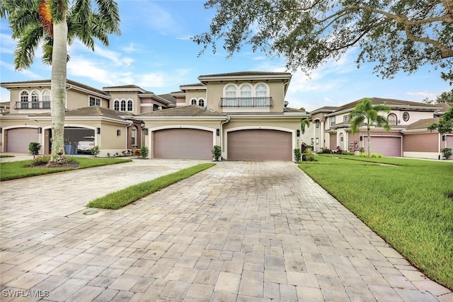 mediterranean / spanish home with stucco siding, decorative driveway, an attached garage, and a front lawn