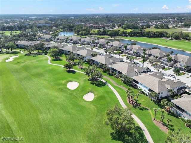 drone / aerial view featuring a residential view, golf course view, and a water view