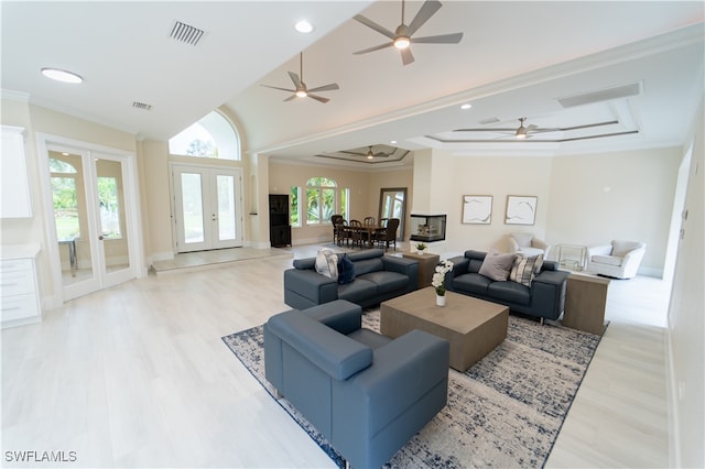 living room with french doors, light hardwood / wood-style floors, high vaulted ceiling, and ornamental molding