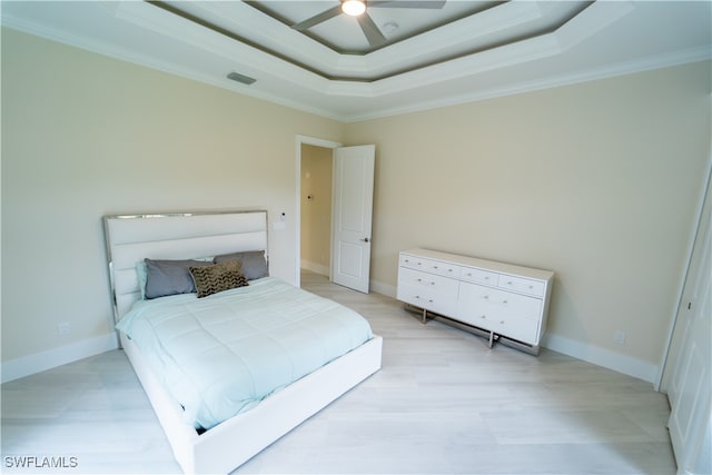 bedroom with crown molding, a raised ceiling, and ceiling fan