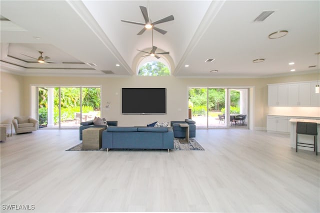 living room featuring a wealth of natural light, crown molding, and light hardwood / wood-style floors