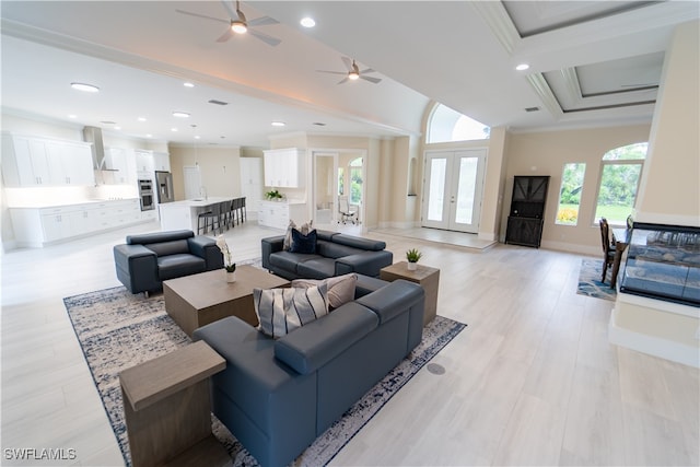 living room with light hardwood / wood-style floors, crown molding, french doors, and ceiling fan