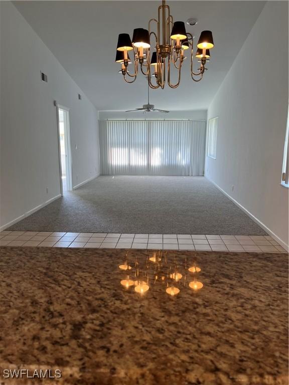 4130 Looking Glass Ln Unit 3802, Naples, FL 34112 - unfurnished room with carpet flooring, a chandelier, tile patterned flooring, vaulted ceiling, and baseboards