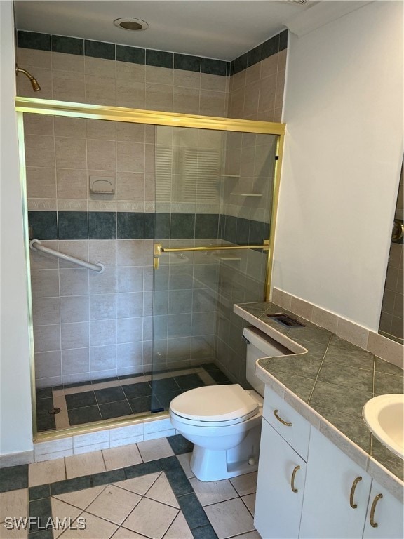 bathroom with tile patterned floors, an enclosed shower, vanity, and toilet