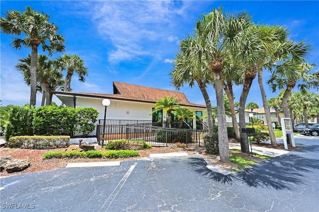 4130 Looking Glass Ln Unit 3802, Naples, FL 34112 - view of front of house with uncovered parking, fence, and stucco siding