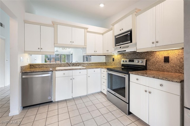 4130 Looking Glass Ln Unit 3802, Naples, FL 34112 - kitchen with stainless steel appliances, ventilation hood, white cabinets, backsplash, and light tile patterned floors
