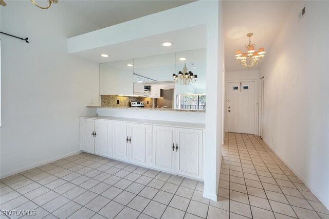 4130 Looking Glass Ln Unit 3802, Naples, FL 34112 - kitchen with a chandelier, freestanding refrigerator, light countertops, light tile patterned flooring, and tasteful backsplash