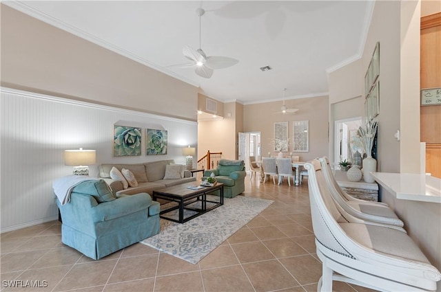 living room featuring ornamental molding, light tile patterned floors, and ceiling fan