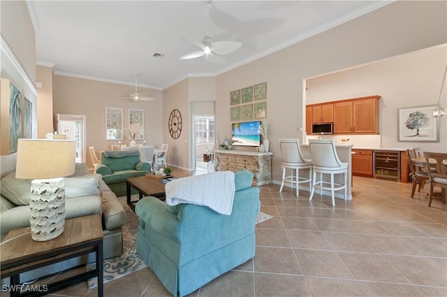 tiled living room featuring ceiling fan and ornamental molding